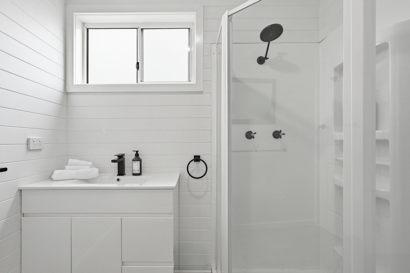 White bathroom with walk-in shower and vanity