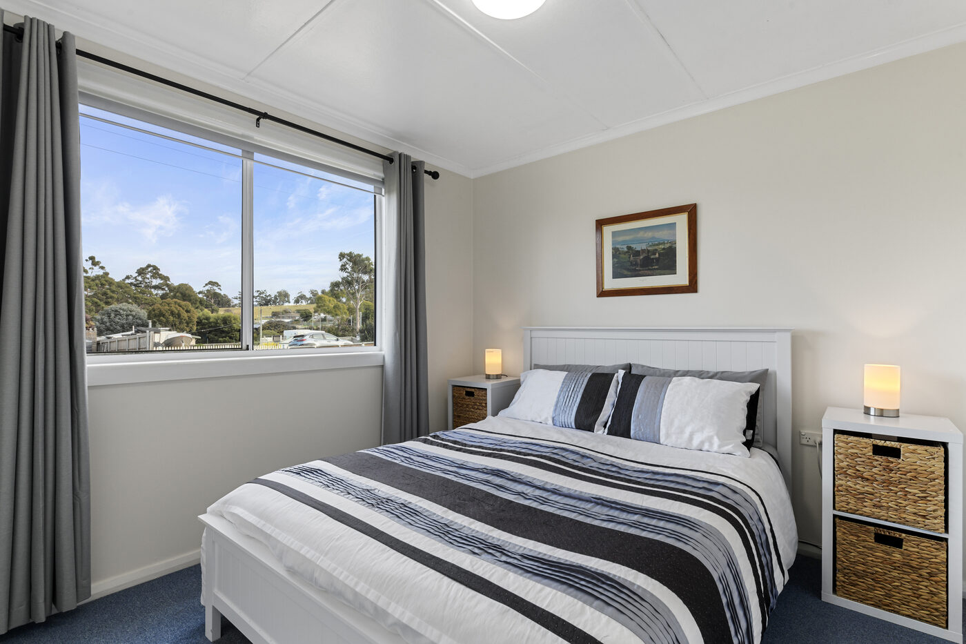 Bedroom with striped bedding and a view to the hills
