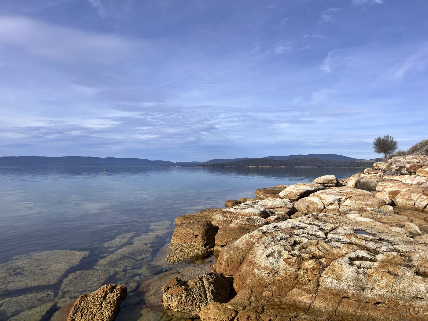 Rocky shoreline and still water on a clear day